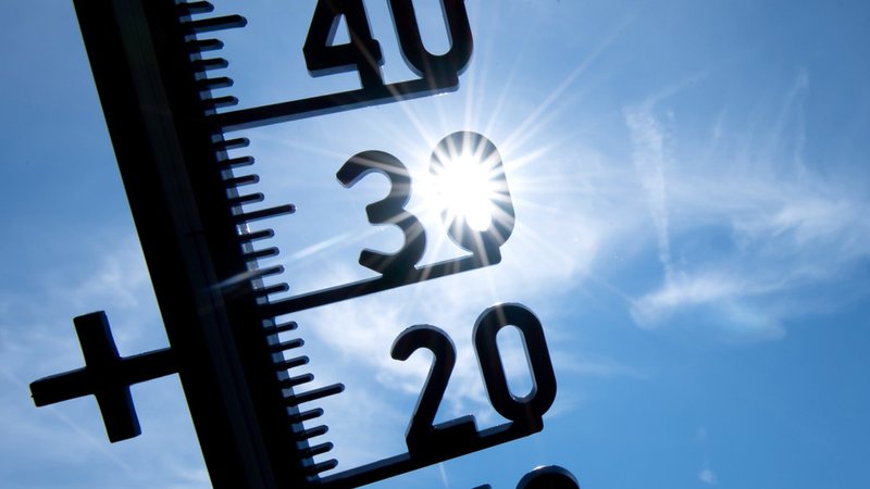 Sonne scheint durch ein Thermometer (Symbolbild).