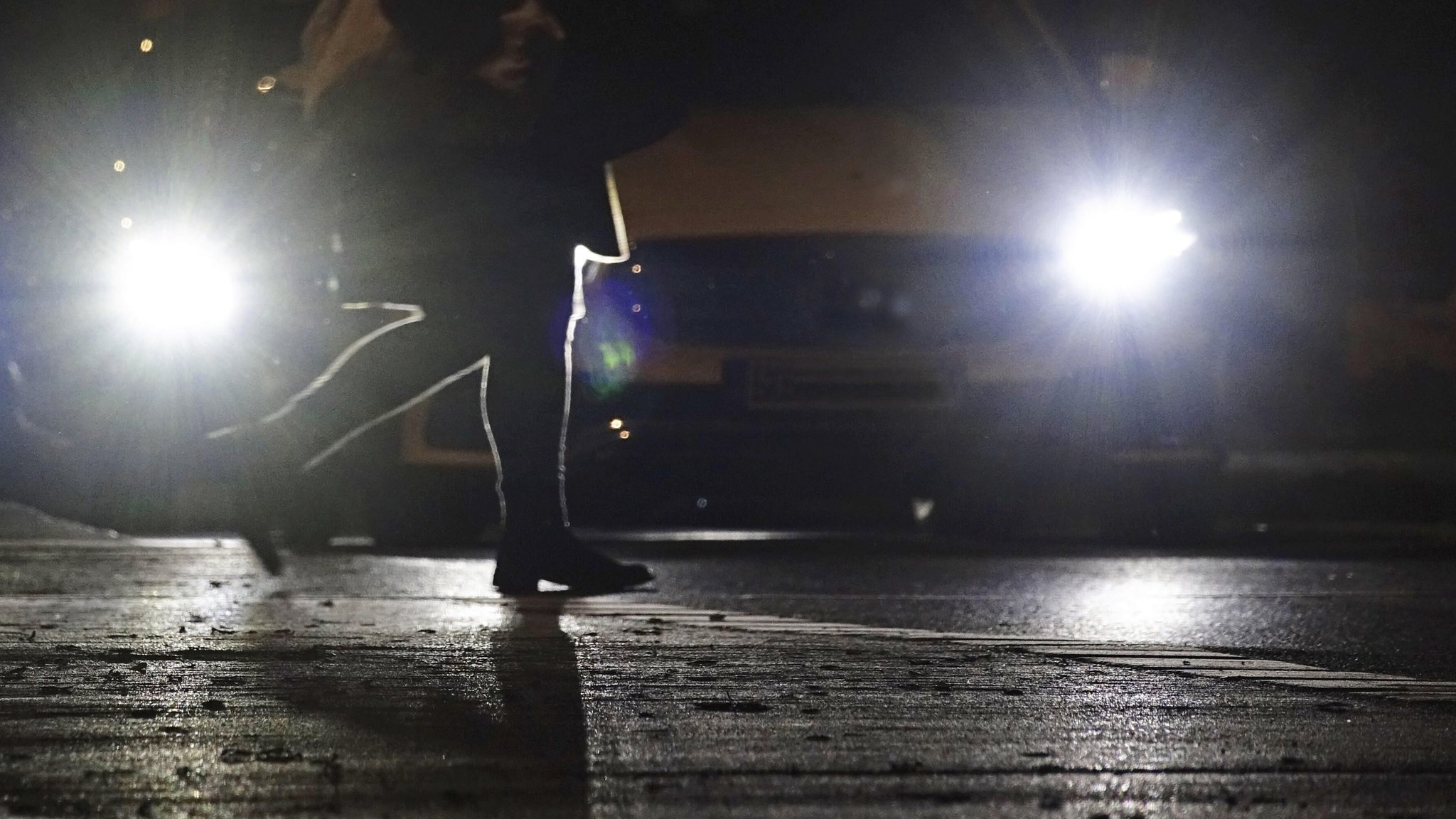 Ein Fußgänger wird in der Dunkelheit von Autolichtern angeleuchtet. | Bild: pa/ imageBROKER | Anette Jäger Ein Fußgänger wird in der Dunkelheit von Autolichtern angeleuchtet.
