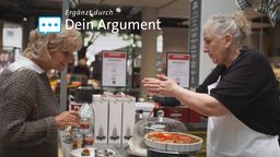 Gesprächssituation zwischen einer Kundin und einer Verkäuferin von Kochgeschirr. Sie präsentiert der Kundin Speisen, die sie frisch gebacken hat.  | Bild:Lukas Graw/BR