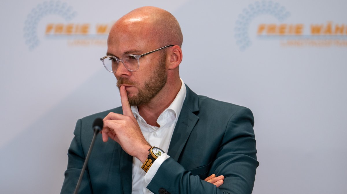 Freie-Wähler-Politiker Fabian Mehring hält sich den Zeigefinger an den Mund