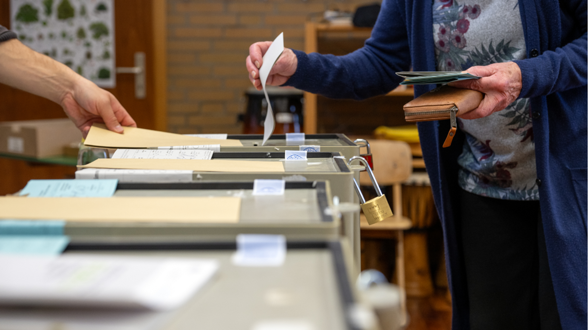 Menschen stehen an einer Wahlurne in Bayern (Symbolbild