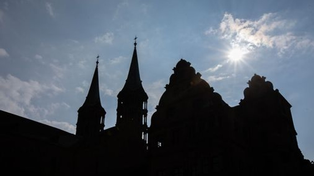 Die Silhouette des Bamberger Doms im Schatten vor weiß-blauem Himmel