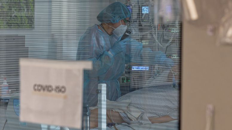 Eine Pflegerin versorgt in der Intensivstation des Luisenhospitals einen Coronapatienten.  | Bild:dpa-Bildfunk/Henning Kaiser