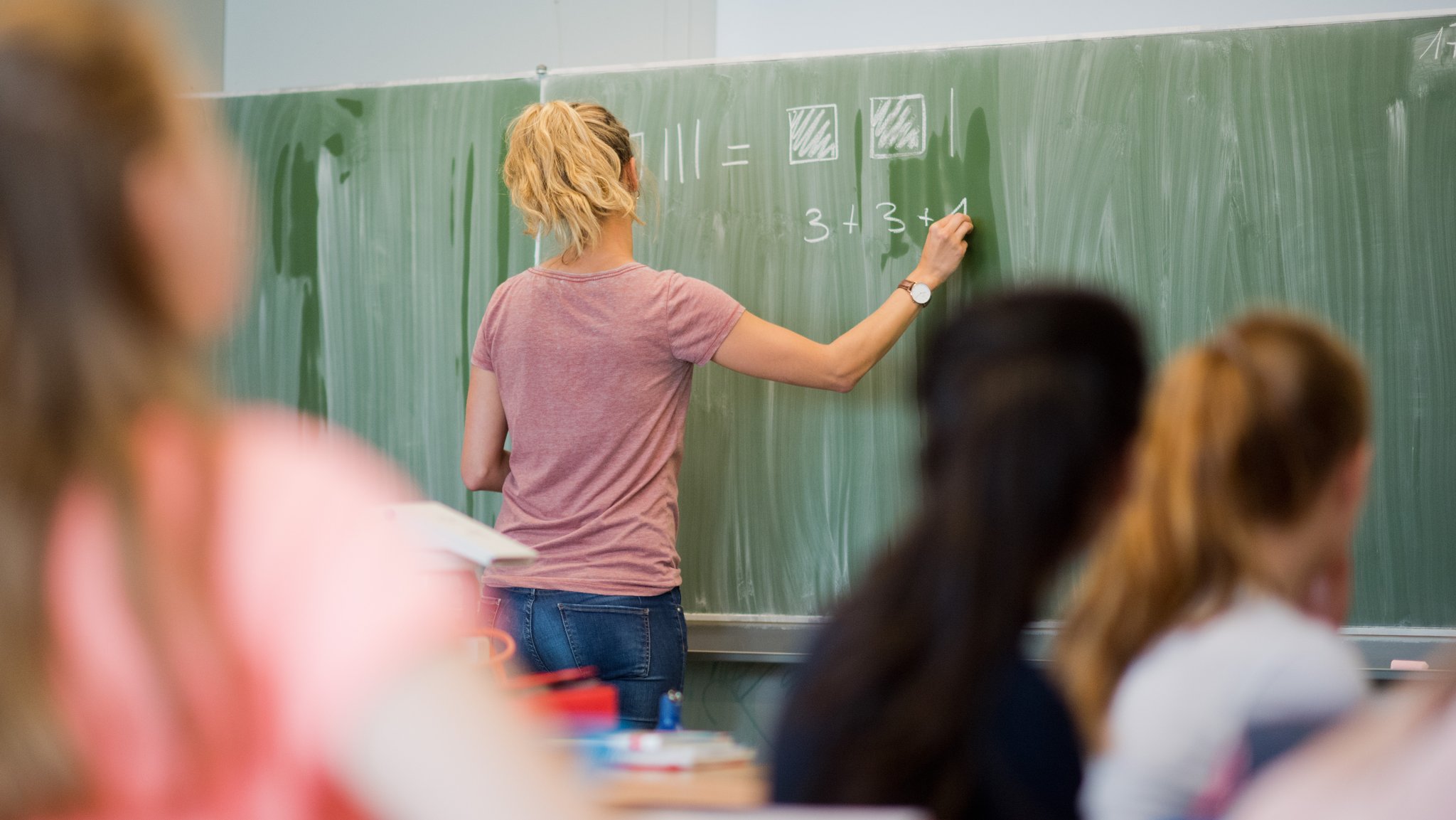 Symbolbild: Lehrerin steht an der Tafel 