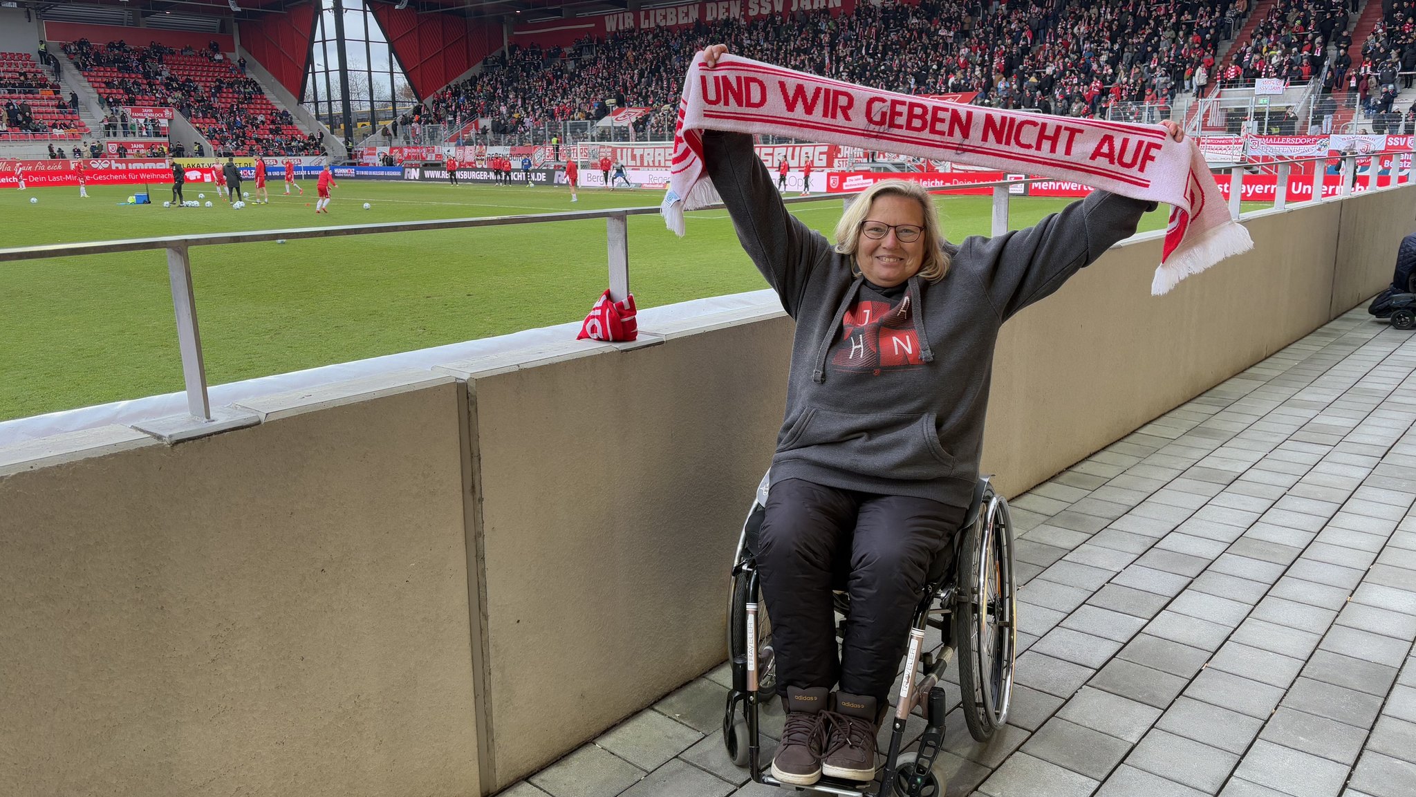 Rollstuhlfahrerin Karin Wagner bei einem Heimspiel des SSV Jahn Regensburg im Stadion.