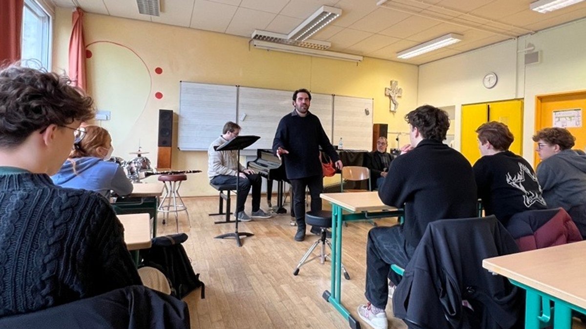 Ein Klassenzimmer mit Schülern und Musikern. 