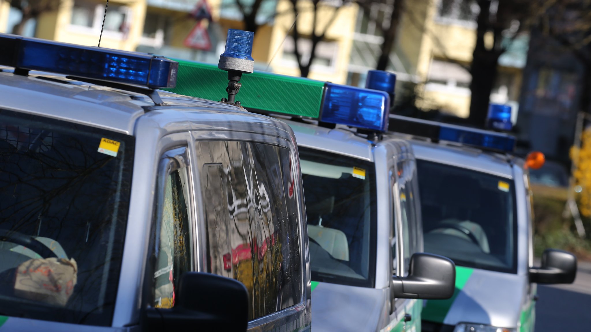 Polizeiautos stehen vor einem Mehrfamilienhaus 