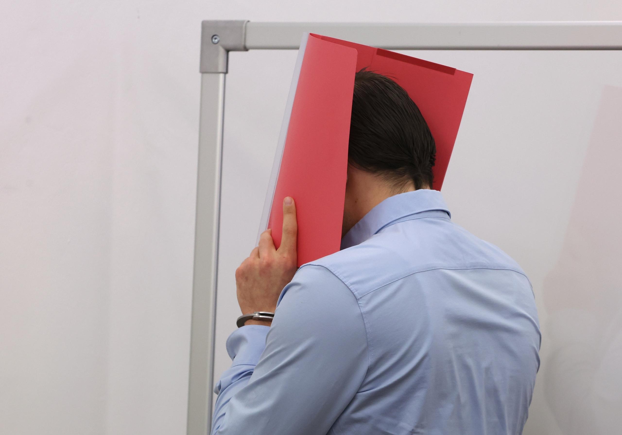 Der Angeklagte im Mordprozess nach der Gewalttat bei Schloss Neuschwanstein verhüllt sein Gesicht.