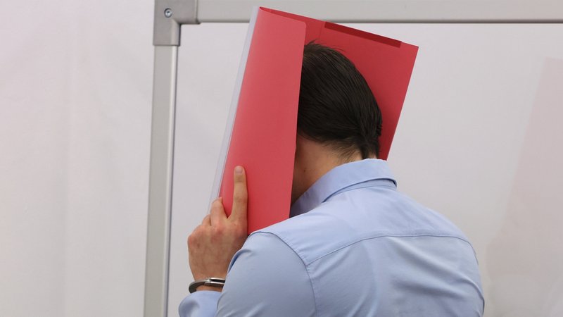 Der Angeklagte im Mordprozess nach der Gewalttat bei Schloss Neuschwanstein verhüllt sein Gesicht. | Bild: dpa-Bildfunk/Karl-Josef Hildenbrand Der Angeklagte im Mordprozess nach der Gewalttat bei Schloss Neuschwanstein verhüllt sein Gesicht.