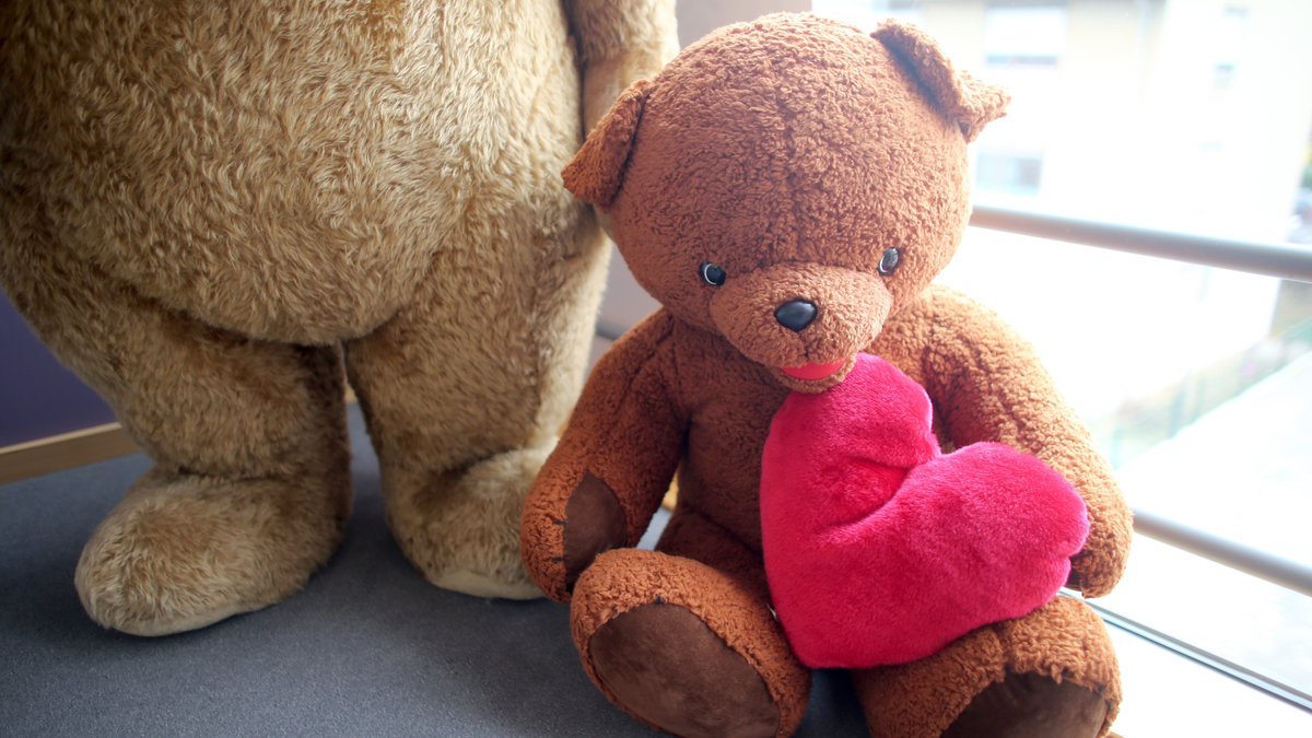 Ein kleiner Teddybär mit einem Herz in den Armen