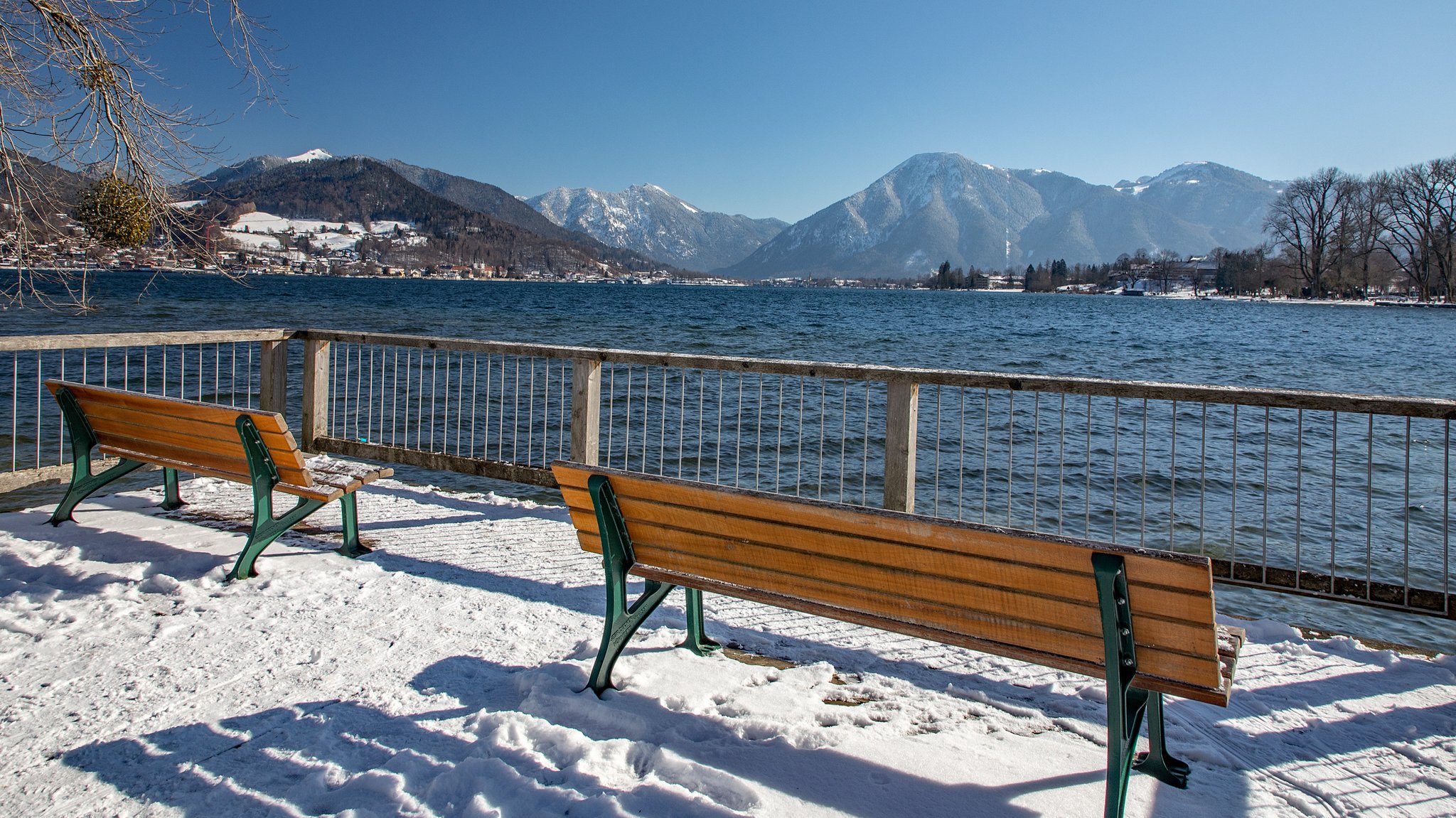 Zwei Bänke im Landkreis Miesbach mit Blick auf den Tegernsee und die Alpenkette im Hintergrund.