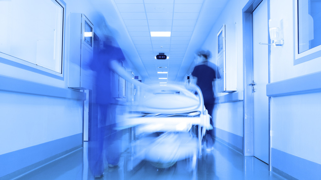 Ein Krankenhausbett wird den Gang entlang geschoben. | Bild: stock.adobe.com/sudok1 Ein Krankenhausbett wird den Gang entlang geschoben.