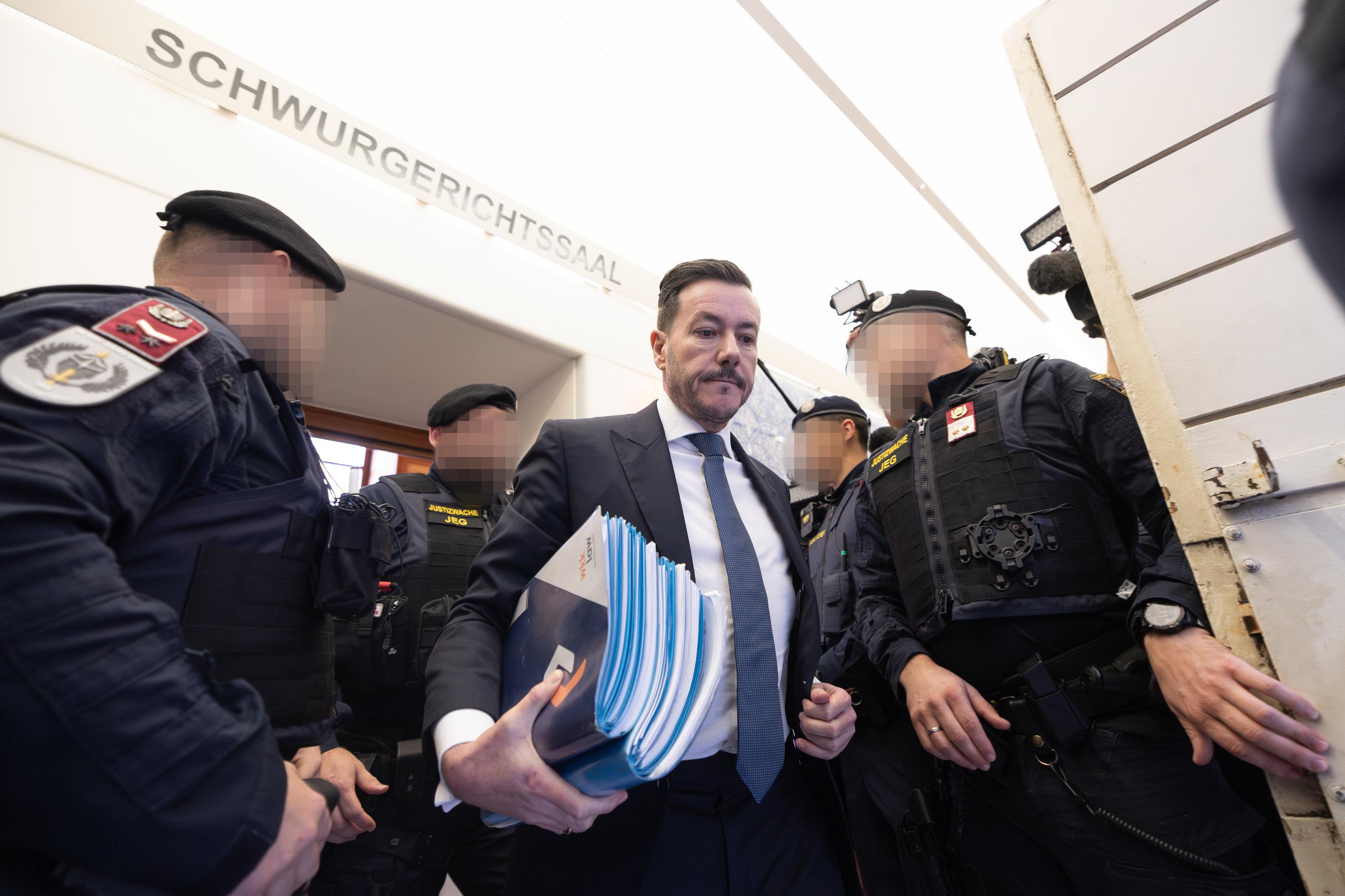 Der Angeklagte Rene Benko verlässt in einer Pause des zweiten Verhandlungstags mit Unterlagen den Schwurgerichtssaal im Landesgericht Innsbruck.
