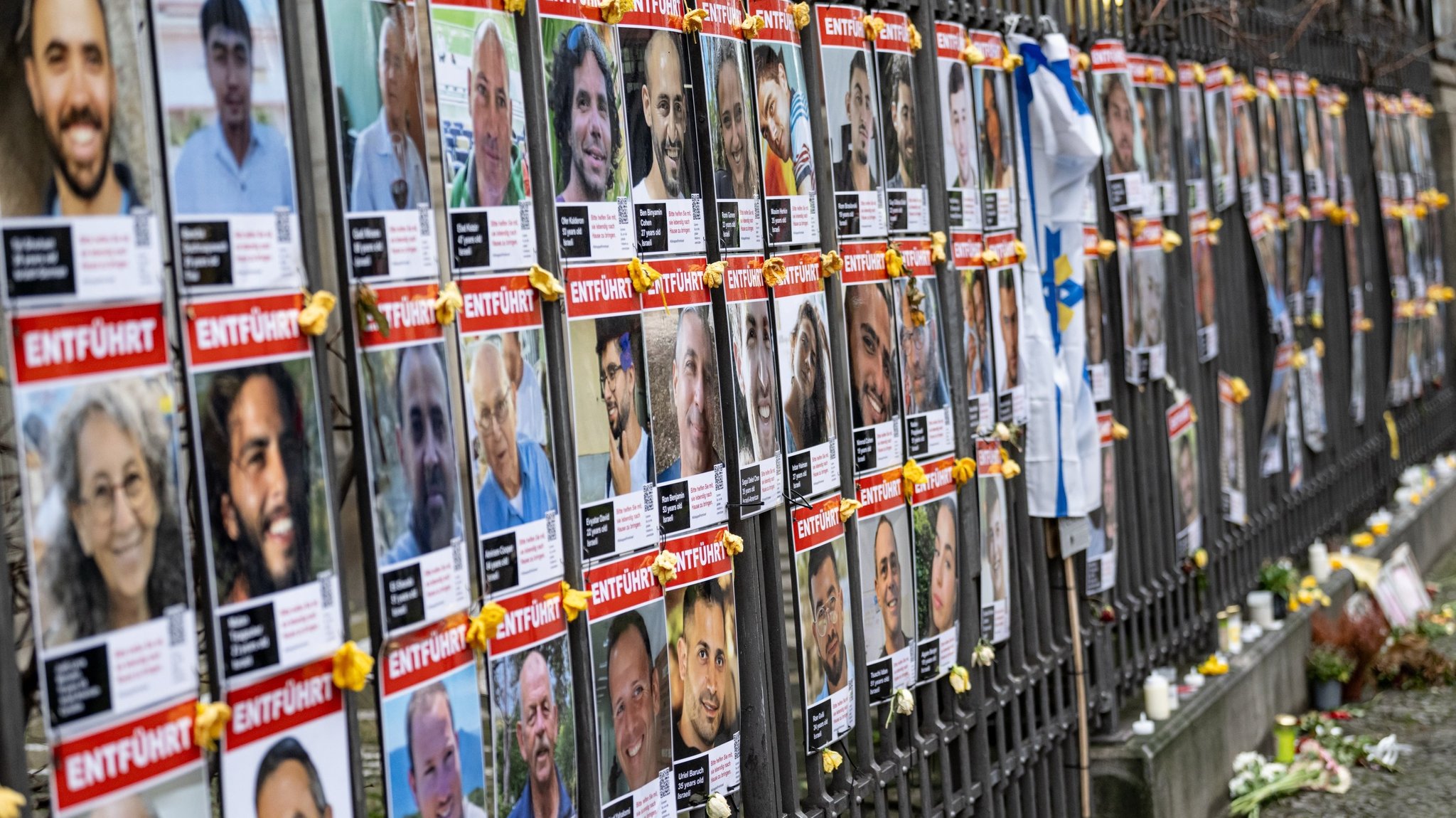 Bilder der von Hamas entführten israelischen Geiseln hängen am Zaun vor der Neuen Synagoge Berlin.