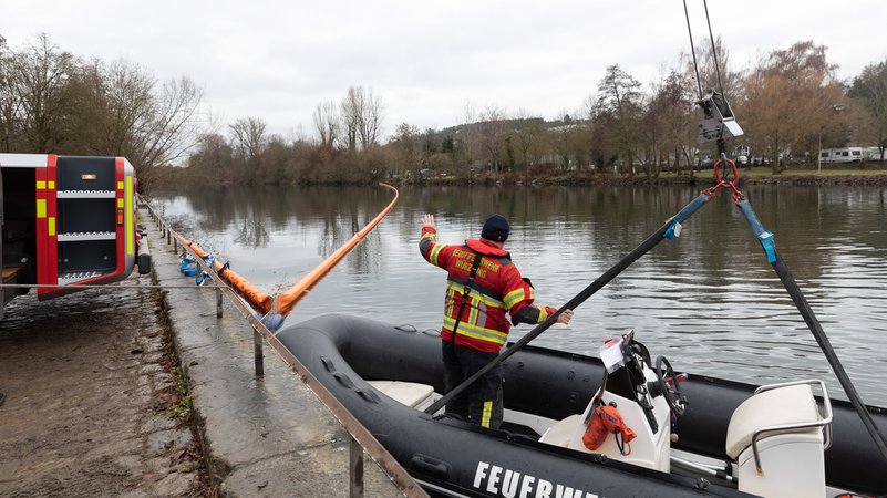 Ein Feuerwehrbot wird auf den Main heruntergelassen, im Hintergrund die Ölsperre quer über den Fluß. | Bild: Christian Weiß (Stadt Würzburg) Ein Feuerwehrbot wird auf den Main heruntergelassen, im Hintergrund die Ölsperre quer über den Fluß.