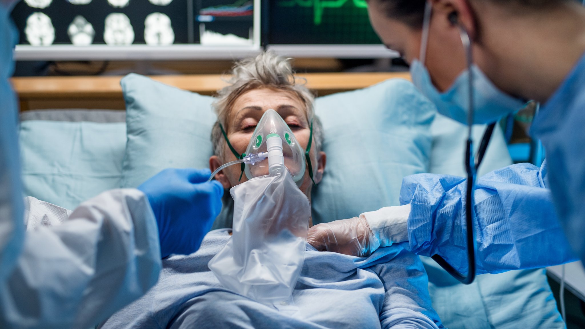 Eine Patientin mit Atemmaske wird im Krankenhaus von Ärzten versorgt. (Symbolbild)