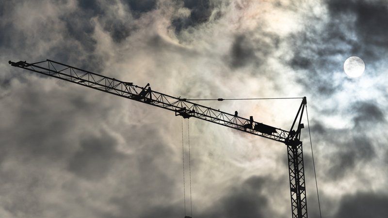 Schwarze Silhouette eines Baustellenkranes vor bewölktem Himmel (Symbolfoto) | Bild: colourbox.de/Frank Heinz Schwarze Silhouette eines Baustellenkranes vor bewölktem Himmel (Symbolfoto)
