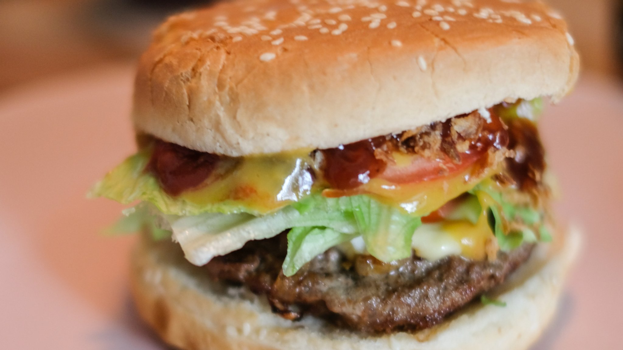 Zu sehen ist in Detailaufnahme ein Burger mit Salat und Soße.