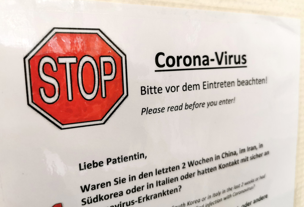  An einem Zugang zu einer Arztpraxis in Hamburg hängt ein Schild mit der Aufschrift "Stop Corona-Virus - Bitte vor dem Eintreten beachten"