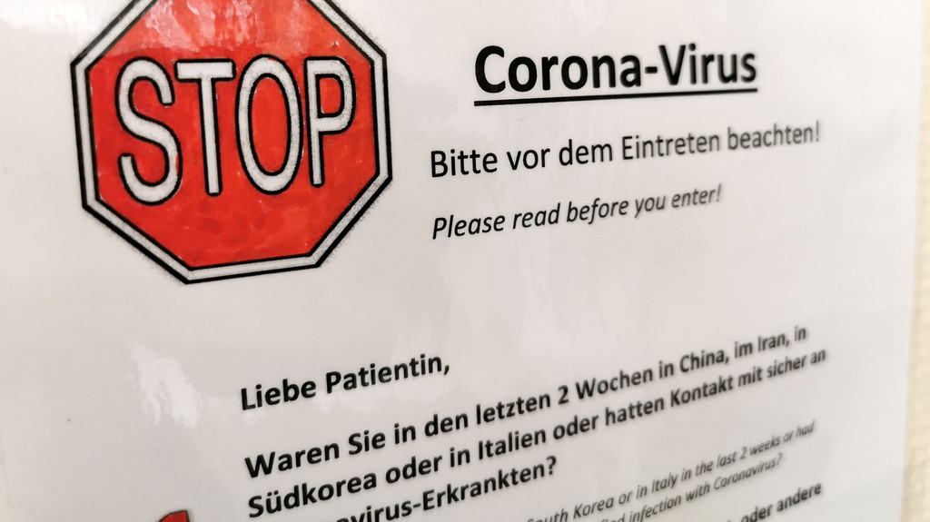  An einem Zugang zu einer Arztpraxis in Hamburg hängt ein Schild mit der Aufschrift "Stop Corona-Virus - Bitte vor dem Eintreten beachten"
