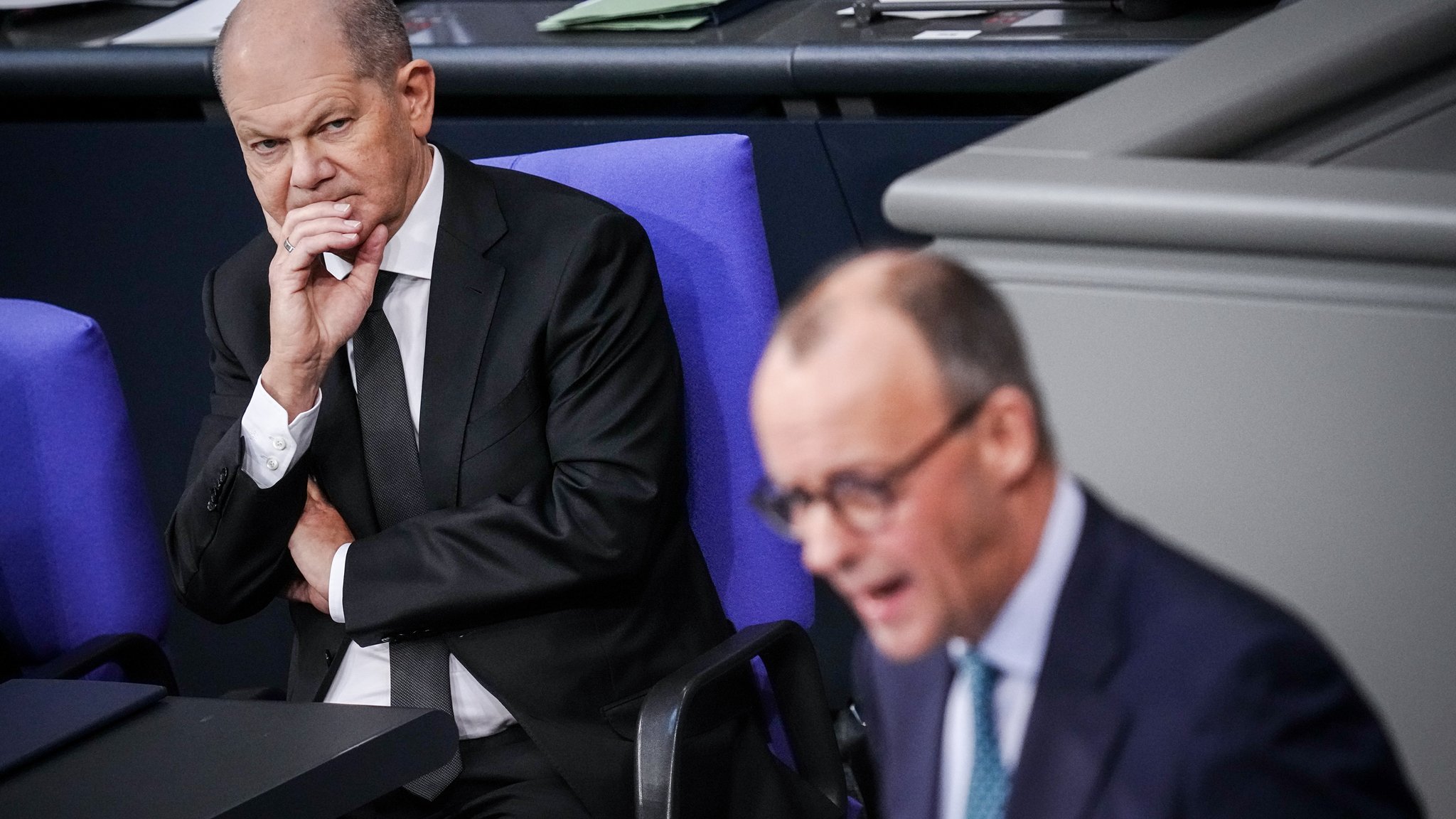 Bundeskanzler Olaf Scholz (l, SPD) verfolgt die Ausführungen des Unionsfraktions-Vorsitzenden Friedrich Merz (CDU)