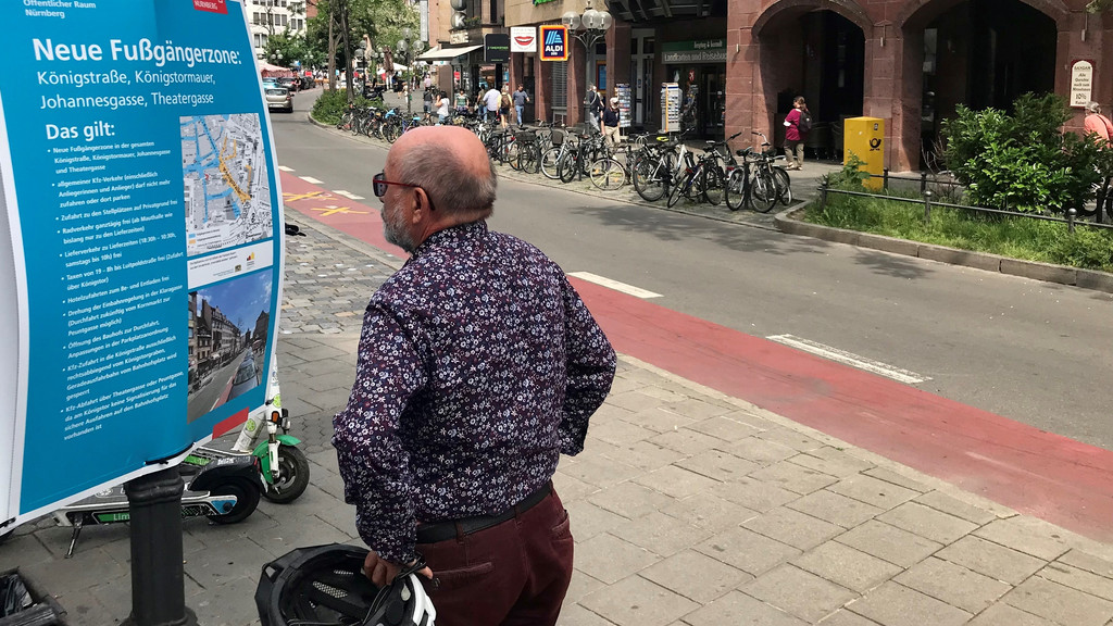 Ein Mann informiert sich an einem Plakat über die neue Fußgängerzone in der Königstraße in Nürnberg.