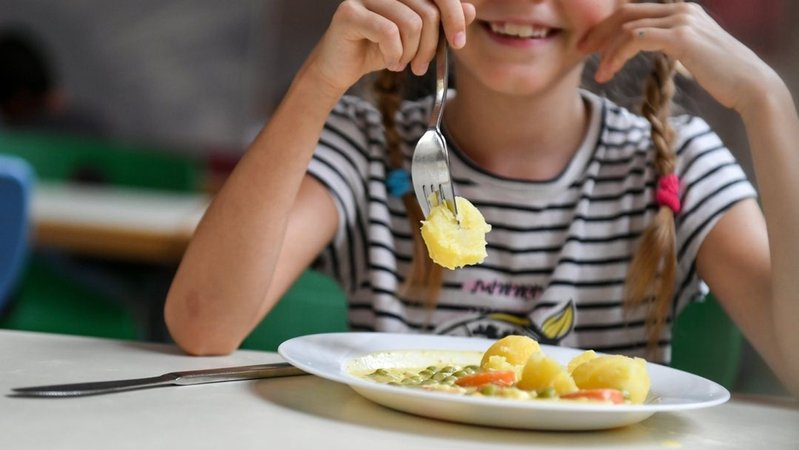 Eine Schülerin sitzt beim Essen in einer Mensa einer Grundschule | Bild: dpa-Bildfunk/Jens Kalaene Eine Schülerin sitzt beim Essen in einer Mensa einer Grundschule