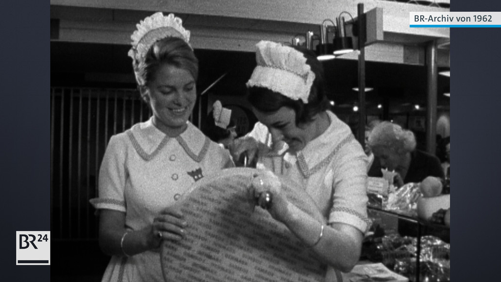 Zwei Frauen beim Aufschneiden eines Käselaibs