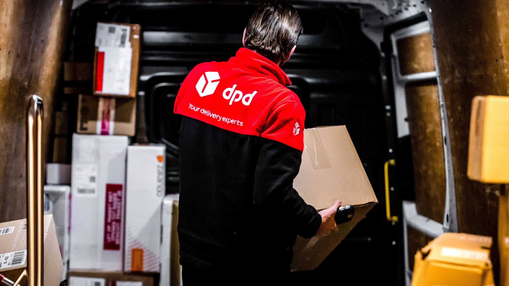 Mitarbeiter des Paketdienstes DPD sortiert Pakete im Paketsortierzentrum