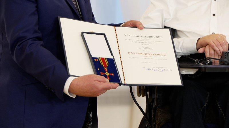 Die Verleihungsurkunde und das Verdienstkreuz für Julian Wendel | Bild: BR Die Verleihungsurkunde und das Verdienstkreuz für Julian Wendel