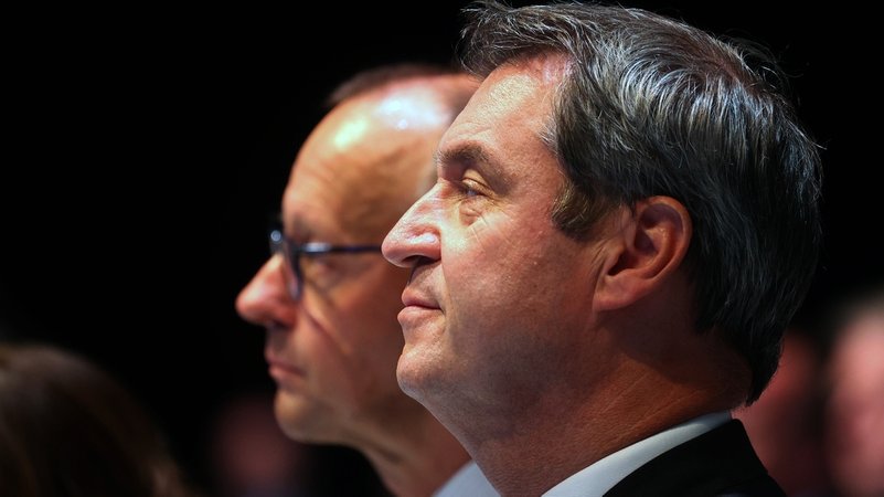 Markus Söder, CSU-Vorsitzender und bayerischer Ministerpräsident (r) und Friedrich Merz,Vorsitzender der CDU, stehen beim singen der Hymnen.