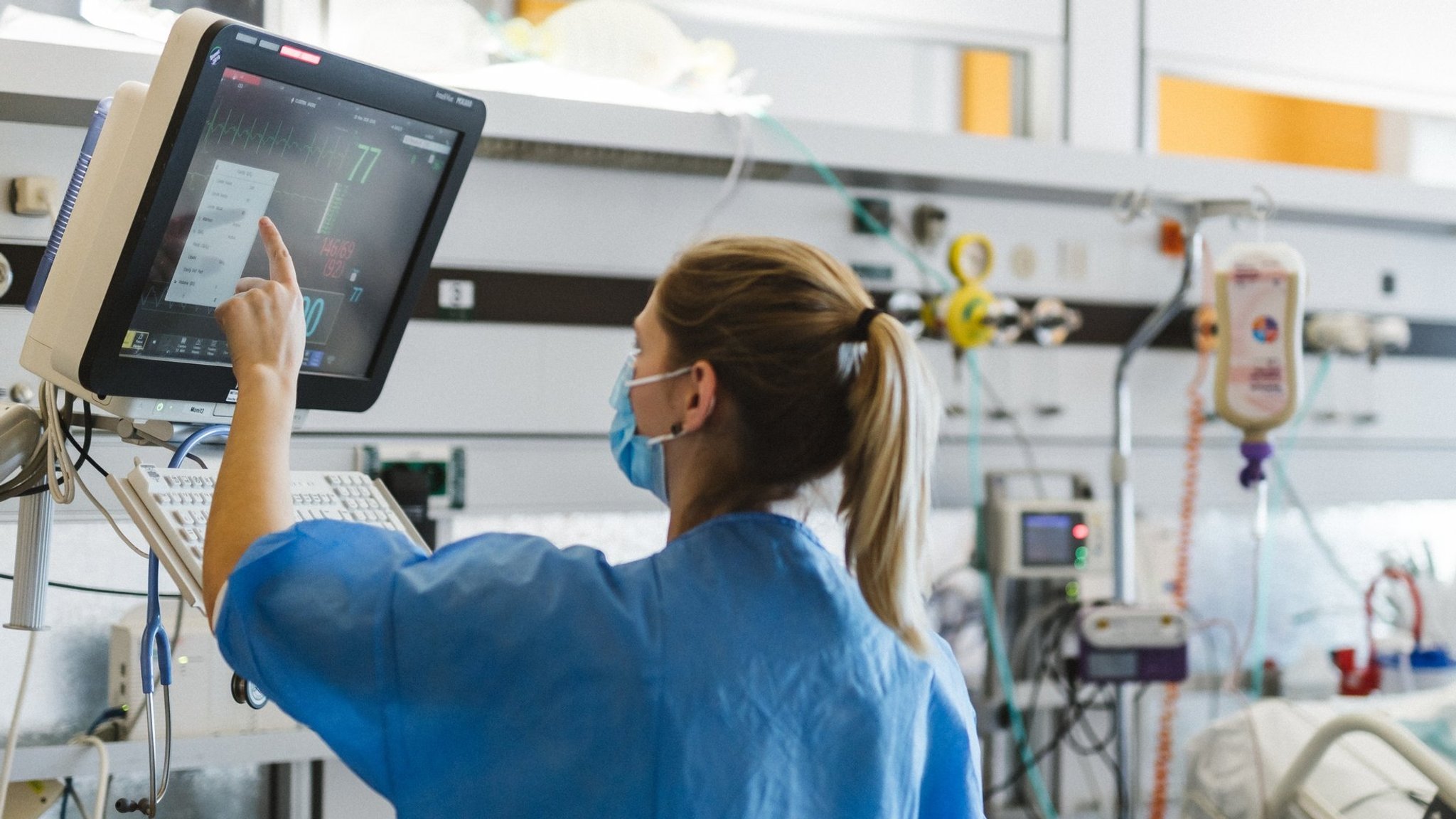 Eine Krankenschwester mit Mundschutz überprüft Werte eines Patienten an einem Überwachungsmonitor. | Bild: stock.adobe.com/Julien Eine Krankenschwester mit Mundschutz überprüft Werte eines Patienten an einem Überwachungsmonitor.