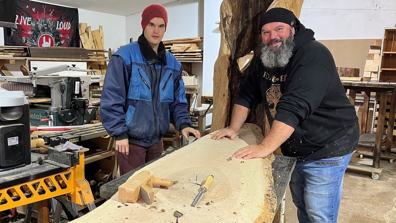 Sozialarbeiter und Holzkünstler Thomas Schenk mit Florian Offinger in der Werkstatt an einem langen Eschenbrett. 