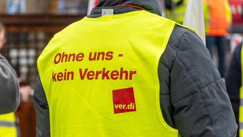 Verdi Streik am Flughafen Franz Josef Strauß in München. Mitarbeiter des öffentlichen Dienstes mit Verdi Warnweste mit der Aufschrift: Ohne uns kein Verkehr | Bild: picture alliance / CHROMORANGE | MICHAEL BIHLMAYER Verdi Streik am Flughafen Franz Josef Strauß in München. Mitarbeiter des öffentlichen Dienstes mit Verdi Warnweste mit der Aufschrift: Ohne uns kein Verkehr