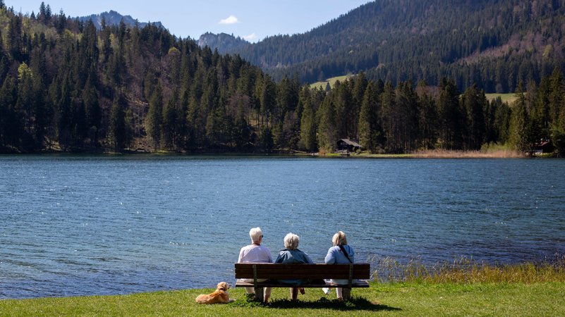 Drei Personen auf einer Bank am Spitzingsee. | Bild: picture alliance / Goldmann | Goldmann Drei Personen auf einer Bank am Spitzingsee.