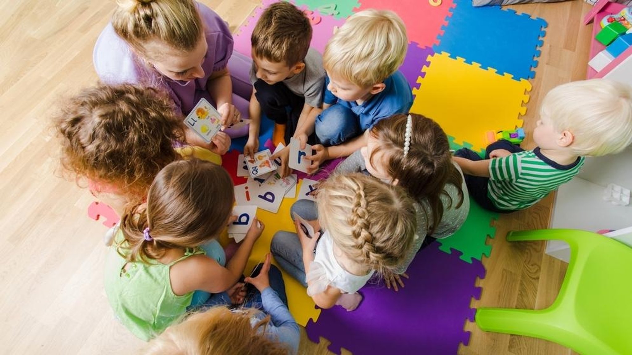 Eine Erzieherin mit einer Gruppe Kinder in einer Kindertagesstätte.