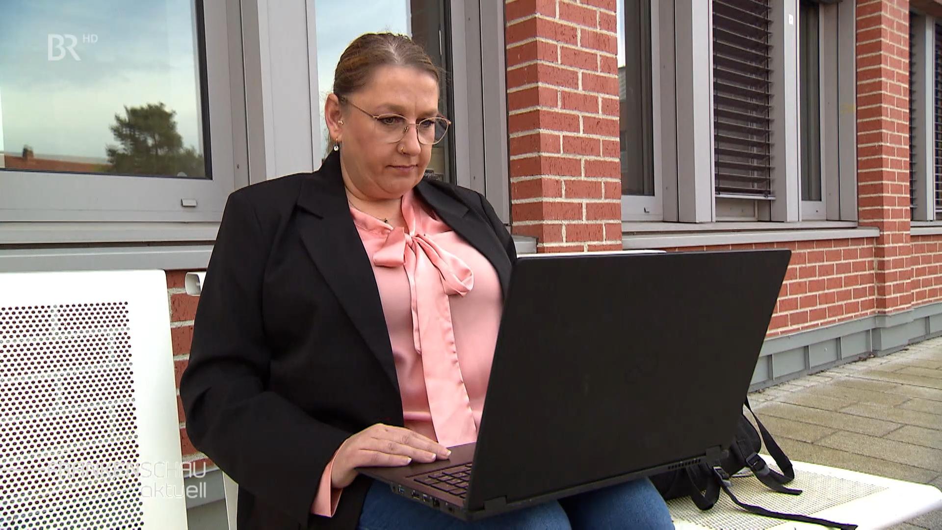 Eine Frau am Laptop, die auf einen Geldwäsche-Betrug hereingefallen ist.