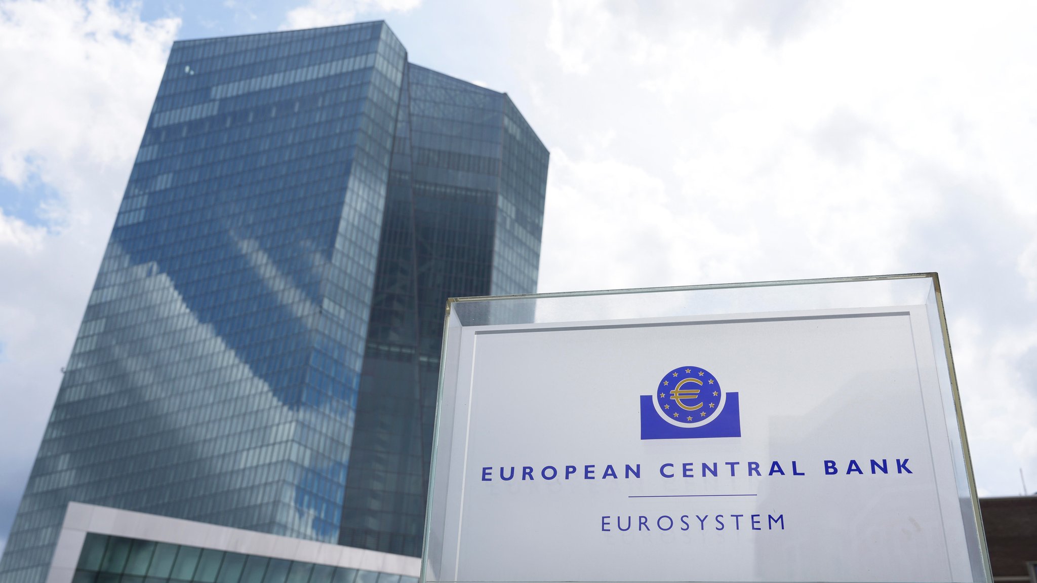 Die Hochhaustürme der EZB in Frankfurt. Im Vordergrund: Das Logo der Bank