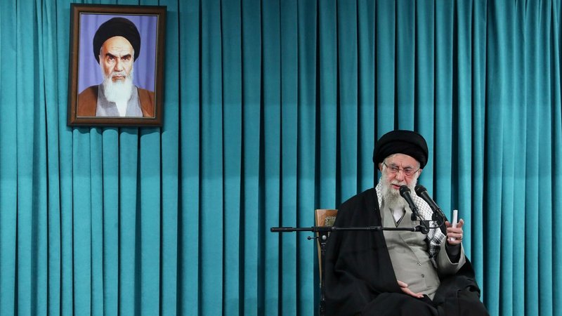 Der inzwischen verstorbene Oberste Führer Ajatollah Ali Chamenei spricht unter einem Porträt des verstorbenen Revolutionsgründers Ajatollah Chomeini in ein Mikrofon (Archivbild) | Bild: Uncredited/Office of the Iranian Supreme Leader/dpa Der inzwischen verstorbene Oberste Führer Ajatollah Ali Chamenei spricht unter einem Porträt des verstorbenen Revolutionsgründers Ajatollah Chomeini in ein Mikrofon (Archivbild)