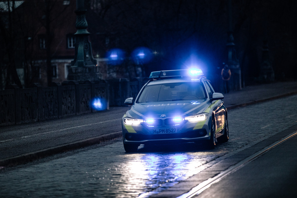Ein Polizeiwagen mit Blaulicht fährt durch die Stadt (Symbolbild).