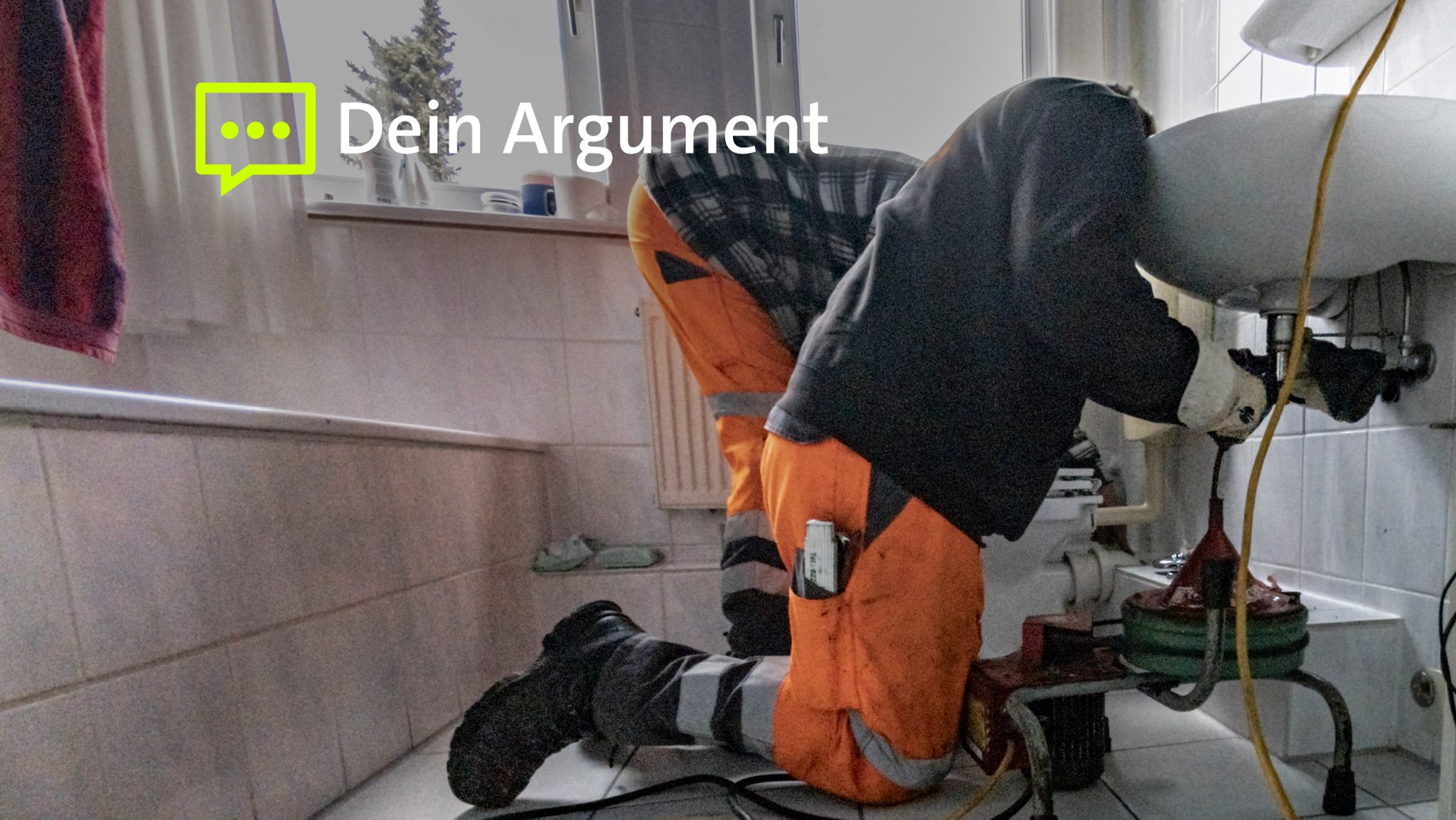 Zwei Handwerker reinigen ein verstopftes Abwasserrohr in einem Badezimmer.