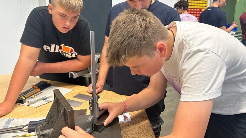 Jugendliche stehen um einen Tisch, wo ihnen eine metallene Gerätschaft | Bild: BR/Martin Gruber Jugendliche stehen um einen Tisch, wo ihnen eine metallene Gerätschaft