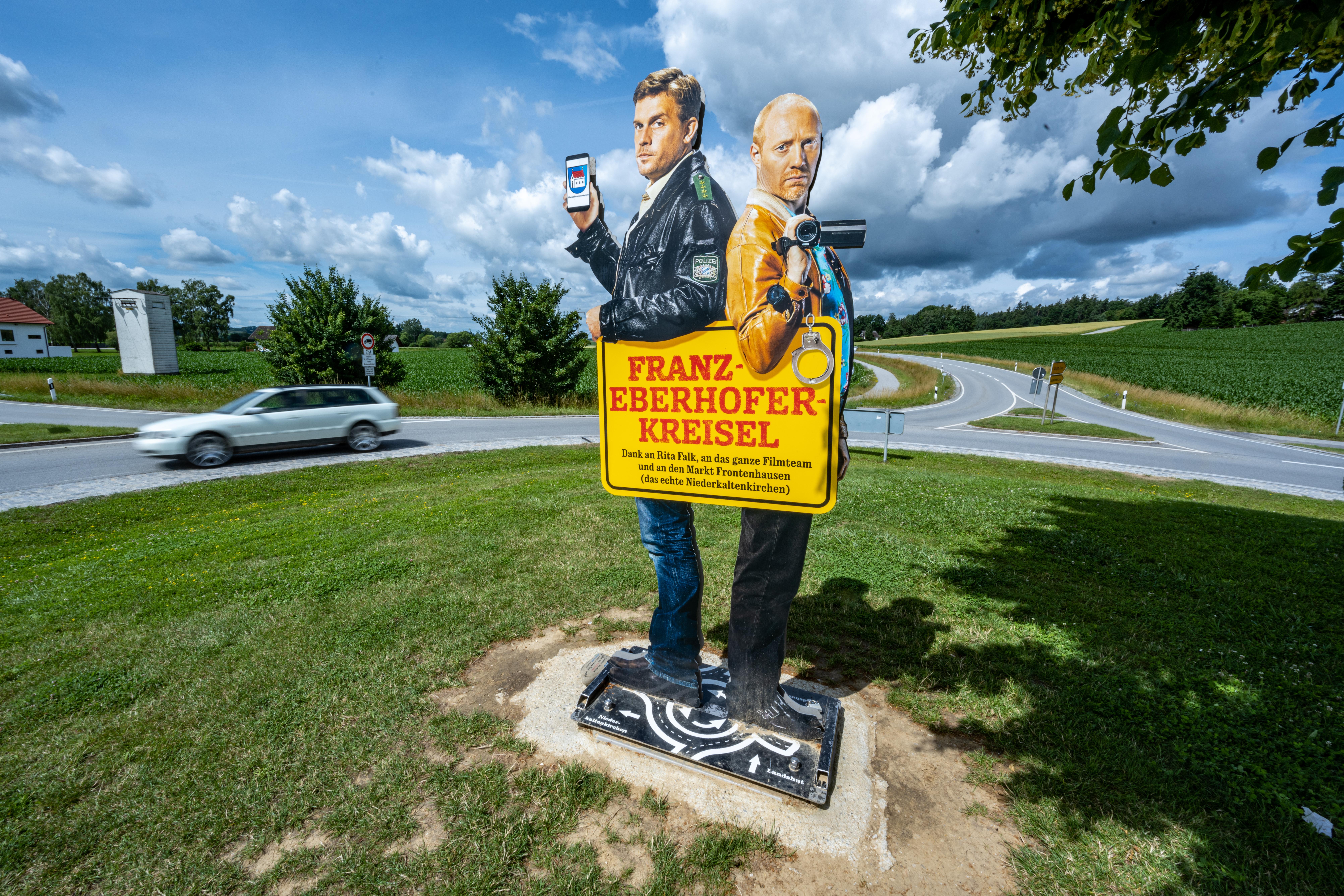 Ein Bild mit den Darstellern der Krimireihe um den Dorfpolizisten Franz Eberhofer steht auf dem Franz-Eberhofer-Kreisel.