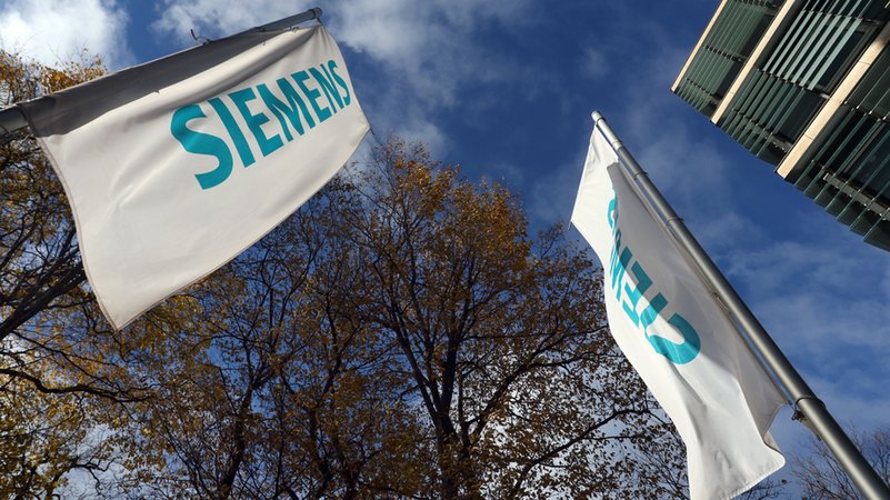 Fahnen mit dem Schriftzug "Siemens" stehen vor der Zentrale des Konzerns im München.