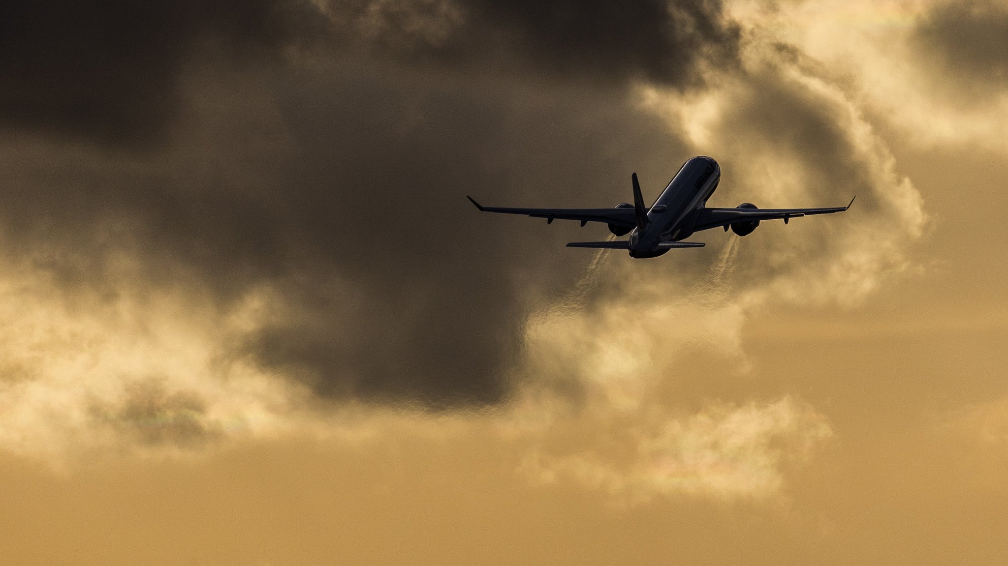 Ein startendes Flugzeug zeichnet sich ab vor der Abenddaemmerung nahe des Flughafen BER in Berlin, 19.02.2023.