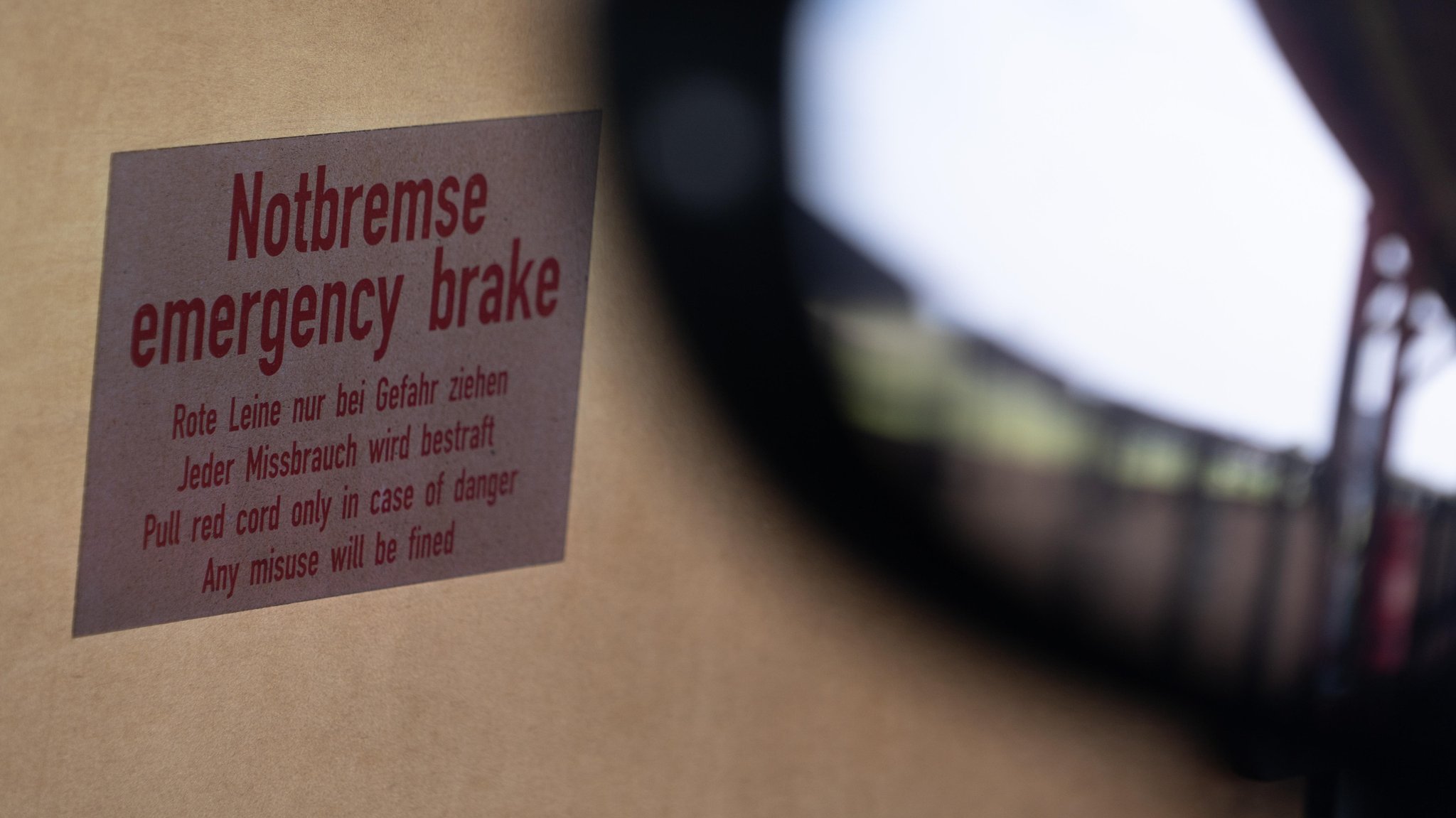 Ein Aufkleber in einem Zug, auf dem "Notbremse emergency brake" steht. (Symbolbild)