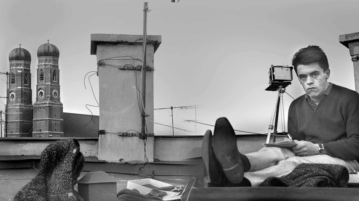 Heinz Gebhardt sitzt vor der Kulisse der Frauentürme auf dem Dach 