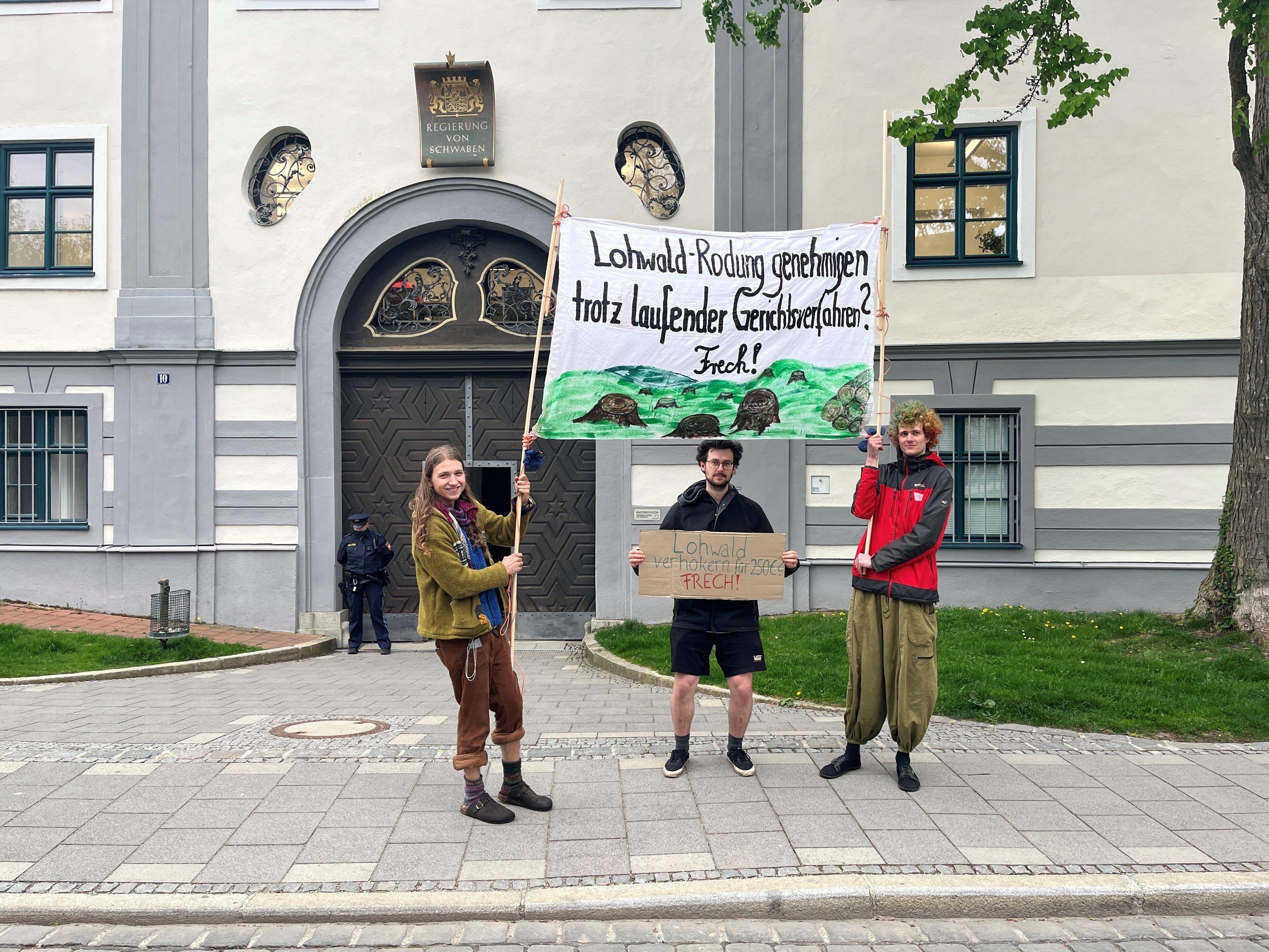 Augsburger Klimacamper vor der Regierung von Schwaben mit Protest-Plakat gegen die Stahlwerkserweiterung.
