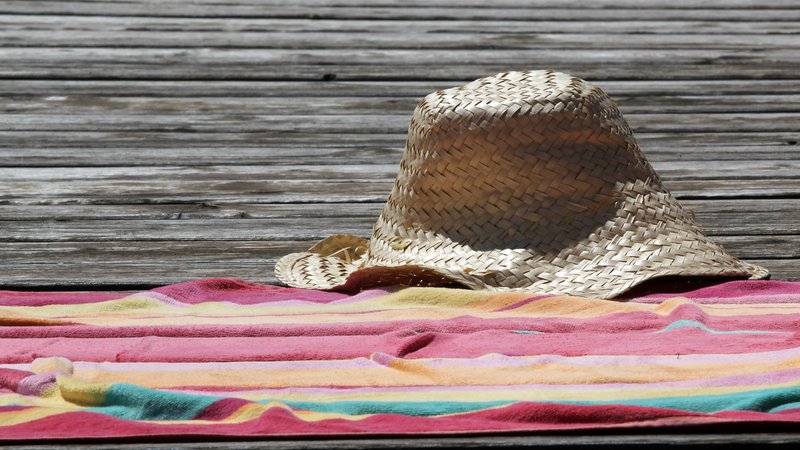Strohhut und Badetuch auf einem Steg | Bild: pa/CHROMORANGE/Karlheinz Pawlik Strohhut und Badetuch auf einem Steg