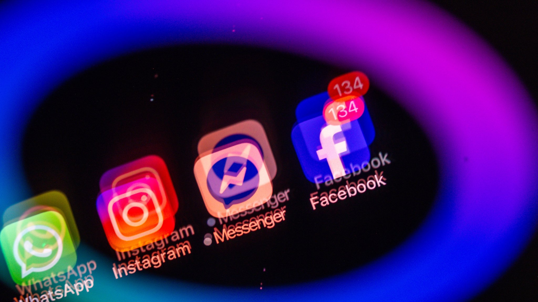 Blauer Meta-Ring. Im Inneren die Logos von WhatsApp, Instagram und Facebook